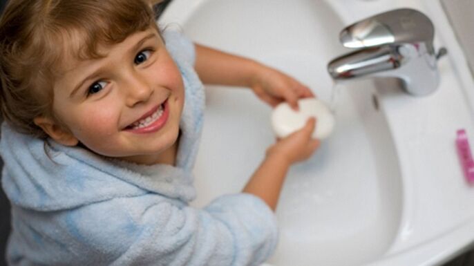 дитина миє руки з милом для профілактики глистів